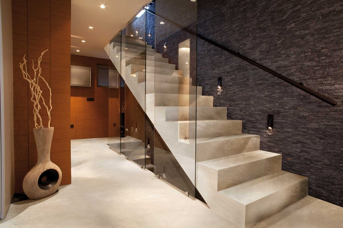 Scară din microciment fără îmbinări, cu design minimalist, finisaj monolitic neted și tonuri minerale calde într-un interior de duplex de lux