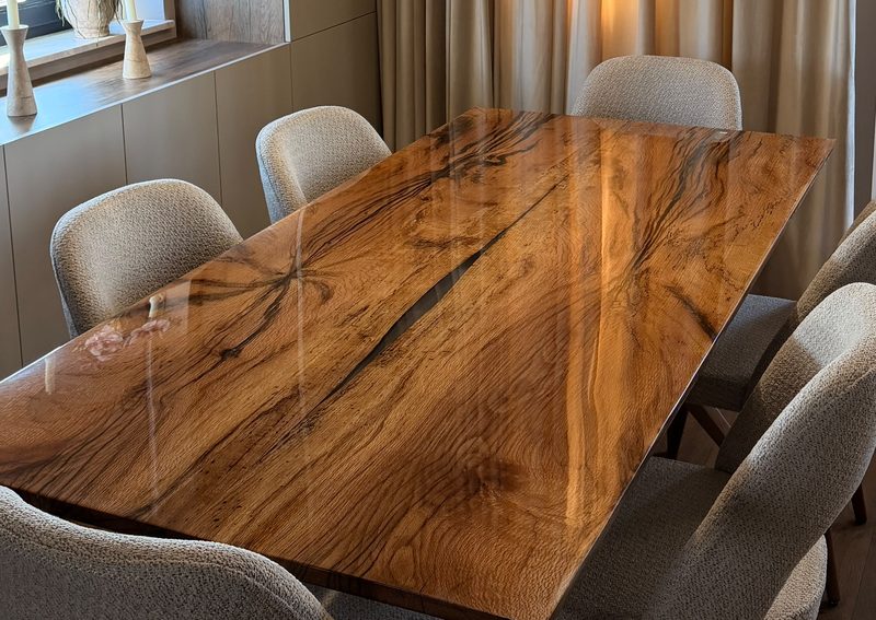 Solid oak dining table with dark mineral streaks, a resin-filled natural crack and a high-gloss epoxy top
